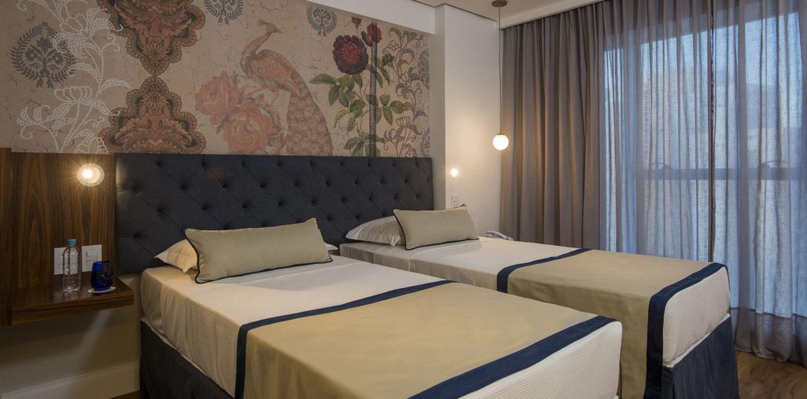 Hotel Luzeiros Recife Zewnętrze zdjęcie The photo shows a modern bedroom featuring two single beds that are neatly made with light-colored blankets and decorative pillows. The headboard of the beds is upholstered in a dark material, giving it a stylish appearance. Behind the beds, there is